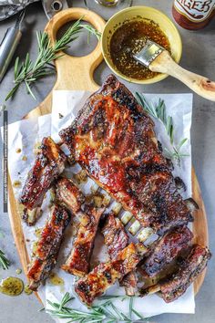 barbecue ribs on a cutting board with sauce and seasoning