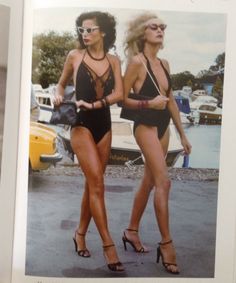 two women in swimsuits are walking next to each other with sunglasses on their heads