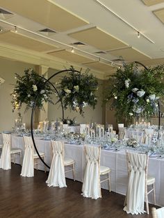 the tables are set with white linens and floral centerpieces