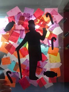 the silhouette of a person holding an umbrella and standing in front of a colorful background