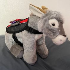 a stuffed donkey is wearing a harness on it's back and has two horns