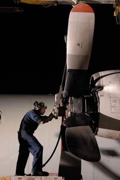 a man working on an airplane in the dark