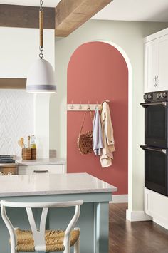 a kitchen with pink walls and white cabinets