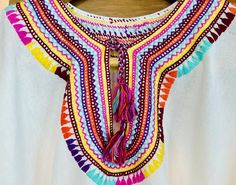 Introducing our exquisite Vintage Mexican Huipil blouse, a vibrant testament to the rich cultural heritage and artisanal mastery of Puebla, Mexico. Handcrafted with meticulous care by skilled artisans from indigenous communities, each Huipil is a unique embodiment of traditional craftsmanship and contemporary flair. Adorned with multicolored embroidery, every stitch tells a story, weaving together centuries of Mexican artistry into a breathtaking tapestry of color and design. Sourced directly from artisan communities, this Huipil captures the essence of Mexican tradition while celebrating the ingenuity of local designers. Designed to embrace the body in relaxed elegance, our Huipil boasts a loose-fitting silhouette that effortlessly flatters Small to Large sizes, ensuring a comfortable and Multicolor Tunic Blouse For Festivals, Artisan Embroidered Summer Top, Folk Multicolor Beach Tops, Artisan Embroidered Tops For Summer, Multicolor Folk Style Tops For Beach, Multicolor Folk Tops For Beach, Festival Blouse With Woven Motifs, Multicolor Geometric Embroidery Beach Tops, Folk Style Festival Tops With Woven Motifs