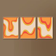 three abstract paintings hang on the wall next to each other in a room with brown walls