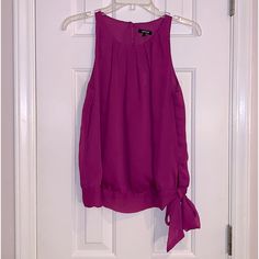 Sleeveless Blouse With Pleading Around Neckline Has Band At The Bottom And Ties In A Bow. The Back Is Keyhole With A Button Closure, Size Small, New With Tags Has An Extra Button Purple Sleeveless Tank Top For Party, Purple Casual Halter Neck Top, Purple Camisole Tank Top For Party, Casual Purple Halter Neck Top, Purple Cami Top For Party, Purple Tank Top For Spring, Purple Tank Vest Top, Purple Tank Top Vest, Purple Casual Tank Top For Party