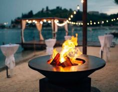 a fire pit sitting on top of a sandy beach