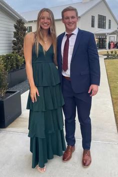 a man and woman standing in front of a house