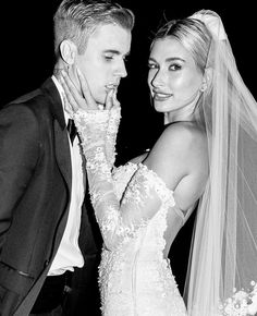 a bride and groom pose for a black and white photo