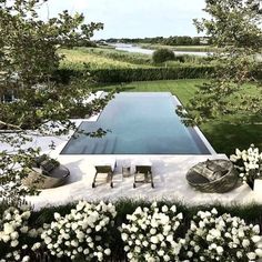 the pool is surrounded by white flowers and trees