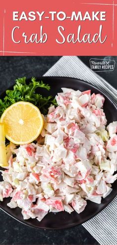 crab salad on a black plate with lemon wedges and parsley in the background