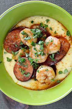 a green bowl filled with shrimp and grits