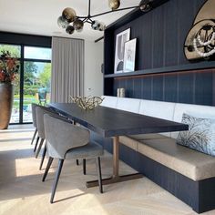 a dining room table and bench in front of a large window