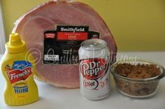 ham, mustard, and other ingredients are sitting on a counter top next to a can of soda