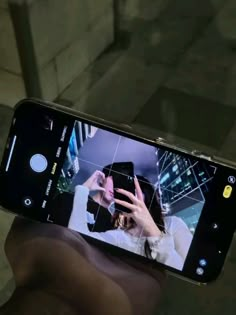 someone is holding up their cell phone to take a selfie with the image on it