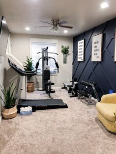 a home gym with equipment and plants in the corner