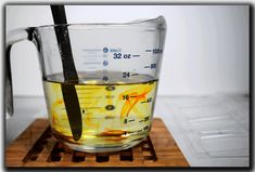 a measuring cup filled with liquid on top of a wooden cutting board