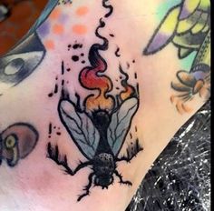 a close up of a person's foot with tattoos on it and an insect