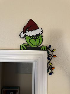 the grin face is on top of a mirror with christmas lights hanging from it's sides