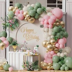 a birthday party with balloons and greenery