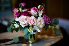 a vase filled with pink and white flowers on top of a table