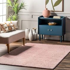 a living room with a couch, chair and rug on the floor in front of a window