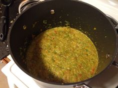 a pot filled with food sitting on top of a stove next to a burner