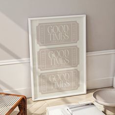 a white framed poster sitting on top of a hard wood floor next to a chair