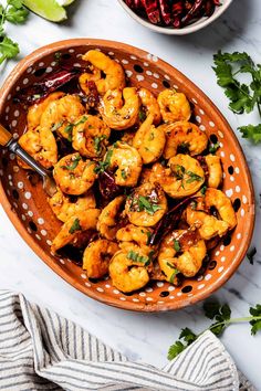 a bowl filled with cooked shrimp and garnished with cilantro