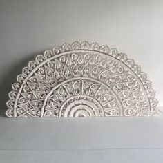 an intricately designed white plate on top of a table