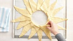 a person is making a sun decoration out of dough