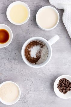 the ingredients to make an easy chocolate cake are shown in small white bowls on a gray surface