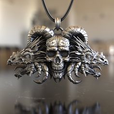 Embark on a mystical journey with our Two Dragons & Skull with Horns Necklace, crafted from pristine 925 sterling silver. This pendant draws inspiration from age-old legends, uniting the fierce elegance of dragons with the haunting allure of a horned skull. Painstakingly handcrafted, the intricate details capture every curve and contour, promising a piece that's as mesmerizing as the tales it represents. Perfect for those captivated by fantasy, mythology, or anyone with a penchant for standout j Collectible Skull Jewelry In Lost Wax Casting, Halloween Skull Jewelry With Engraving, Symbolic Skull Jewelry With Oxidized Finish, Collectible Silver Skull Necklace, Halloween Skull Jewelry Engraved, Halloween Skull-shaped Engraved Jewelry, Halloween Skull Shaped Engraved Jewelry, Spiritual Engraved Skull Jewelry, Fantasy Mythology