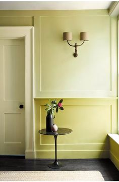 a vase with flowers sitting on top of a table next to a door