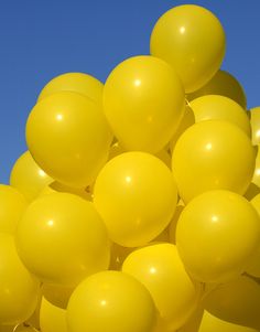 a bunch of yellow balloons floating in the air