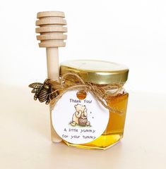 a jar of honey with a wooden stick and label on it that says, thank you a little yummy for your hummy