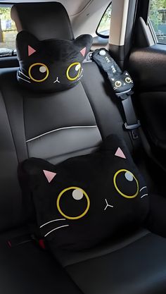 two black cats sitting in the back seat of a car with yellow eyes and whiskers