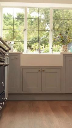 a kitchen with an oven, sink and cabinets in it's center window sill