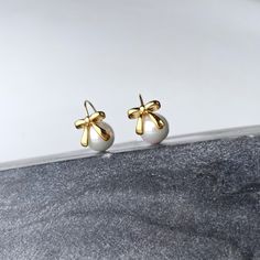 Stay effortlessly trendy and elegant with our Bow + Pearl Earrings. These adorable coquette style earrings feature playful bows that are right on-trend, perfect for adding a touch of charm to any outfit. Whether you wear them everyday or for special occasions, these earrings are a must-have for any fashion-forward individual. Materials: Stainless Steel - Tarnish Free Fresh water pearl Measurements: charm measure 2cm Stackable Jewelry, Coquette Style, Steel Earrings, Fresh Water Pearl, Stainless Steel Earrings, Style Earrings, Steel Jewelry, Stainless Steel Jewelry, Jewelry Plate