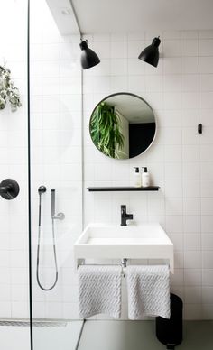 a bathroom with a sink, mirror and shower head in the corner next to it