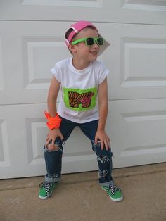 a young boy wearing green sunglasses and a white t - shirt