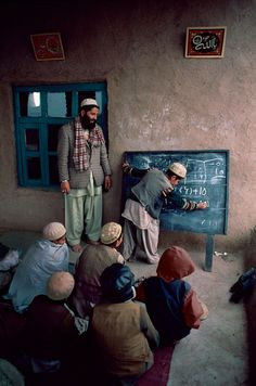 a group of people standing around a blackboard