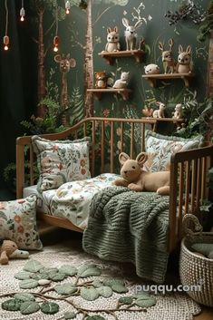 a baby crib with stuffed animals on it in front of a forest themed wall