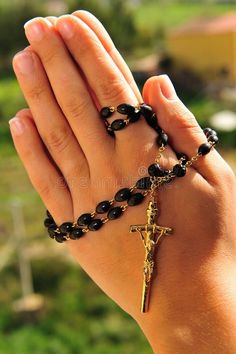 a woman's hand holding a rosary with a crucifix on it