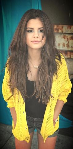 a woman with long hair and yellow cardigan