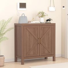 a wooden cabinet sitting in the corner of a room next to a potted plant