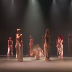 a group of people standing on top of a stage next to each other in front of spotlights