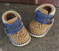 a pair of crocheted baby shoes with blue straps