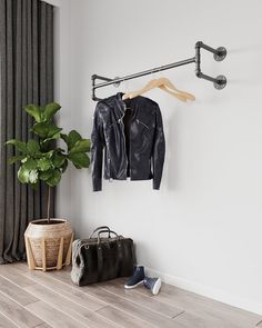 a black leather jacket hanging on a coat rack