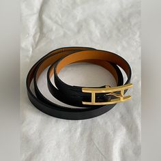 two black and gold belts sitting on top of a white sheet